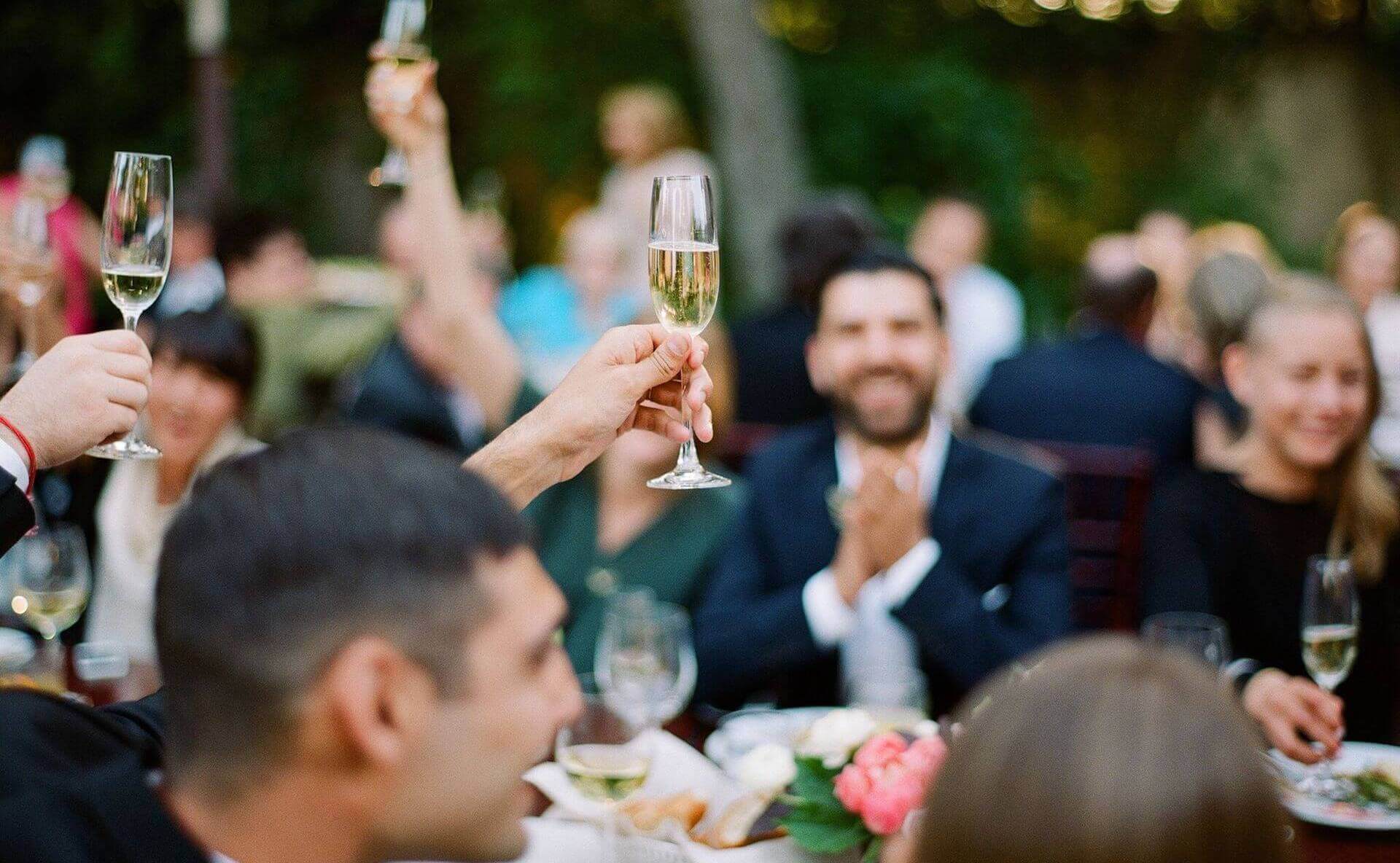 Hands holding up champagne for toast at wedding