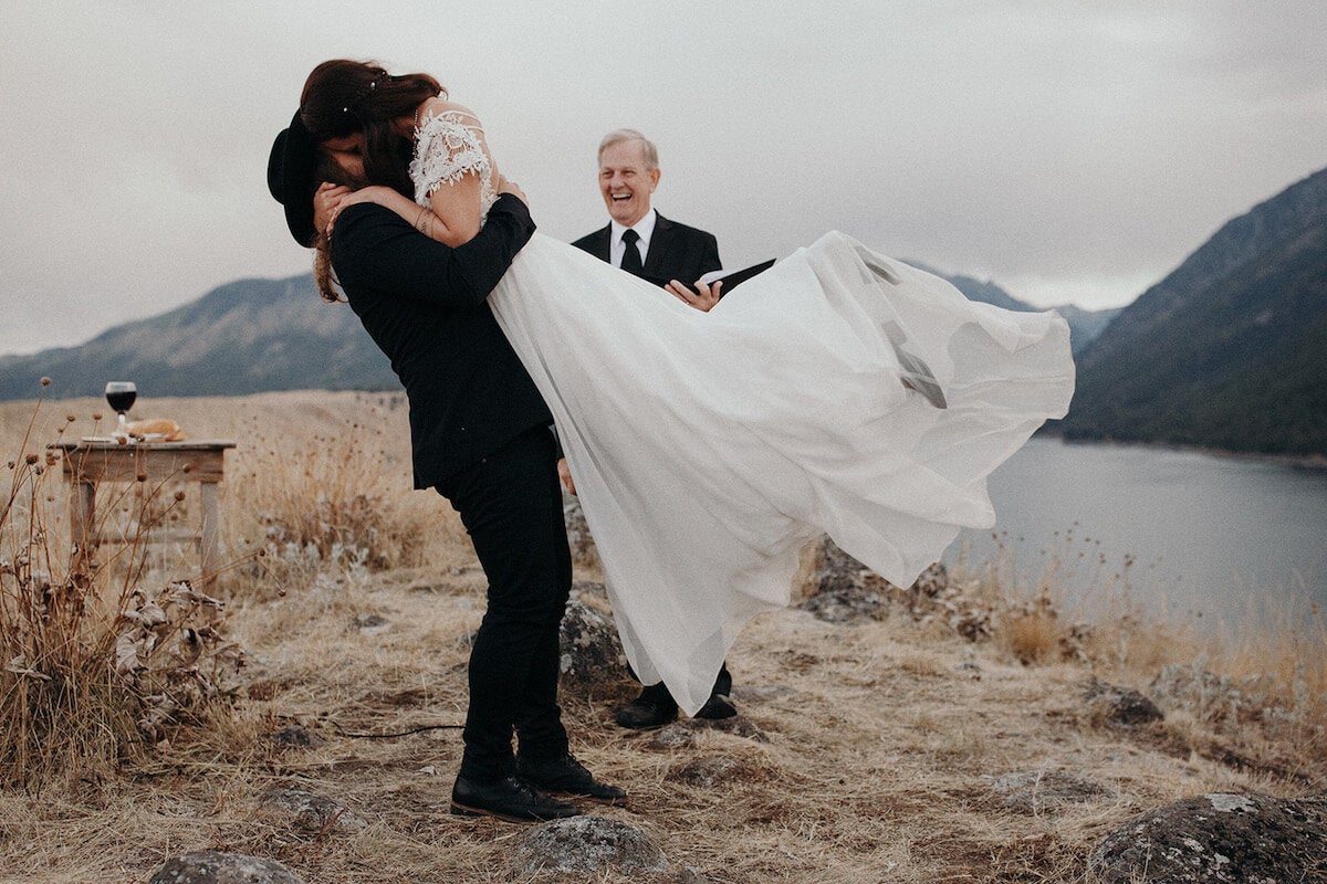 Groom picking bride up for first kiss as man and wife