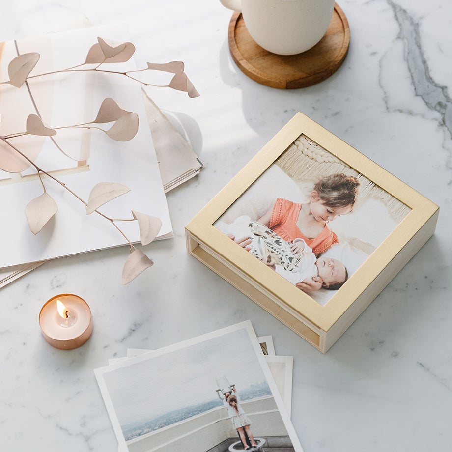 Brass and wood photo display box on marble countertop