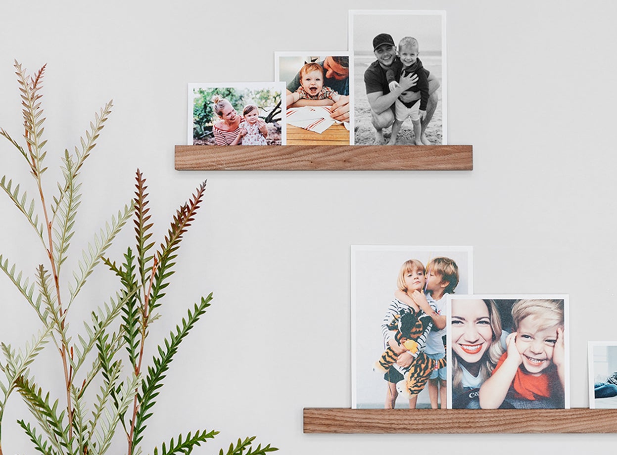 Prints standing on two wall-mounted photo ledges