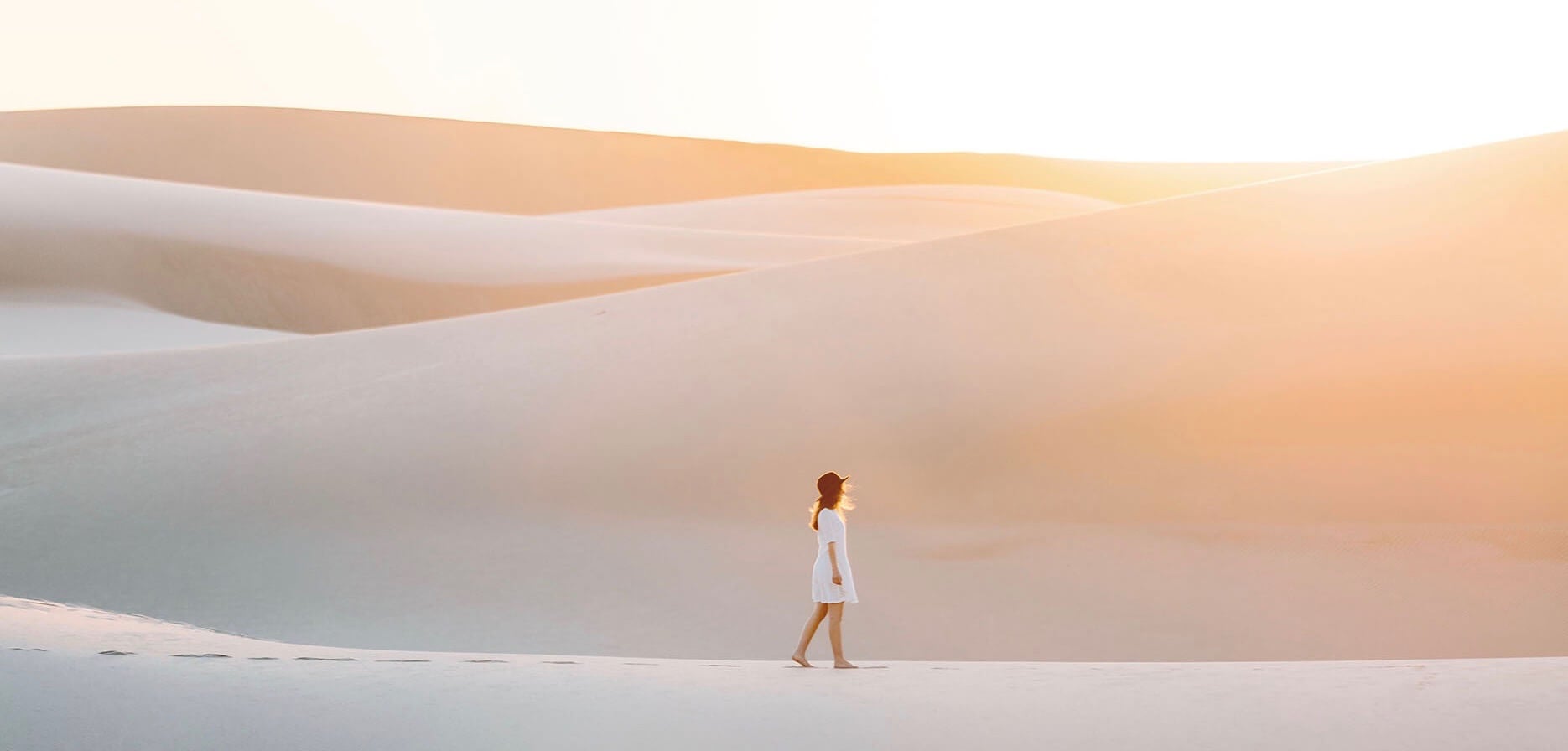 Emilie Ristevski photo of woman walking across sand dunes