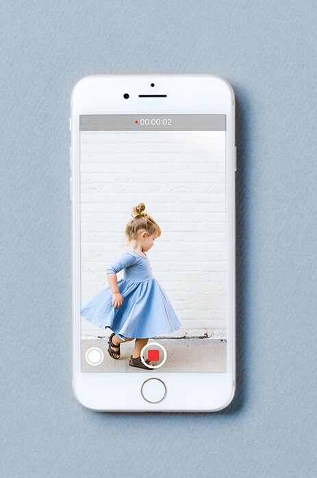 Photo of iphone screen taking video of little girl in blue dress