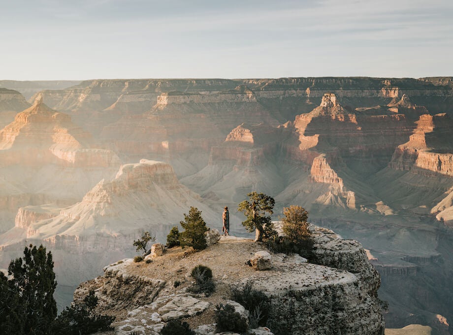 Woman gazing out into vast canyon landscape