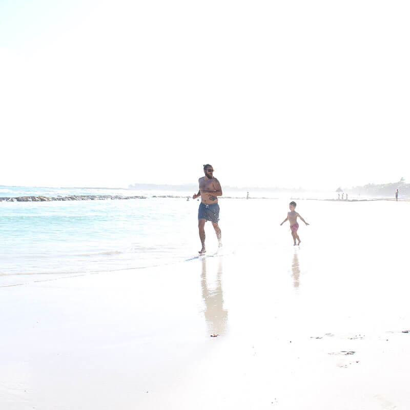 photo of father and son running on beach from at the beach album