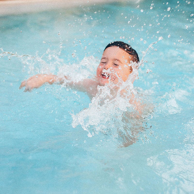 photo of little boy swimming from at the beach album