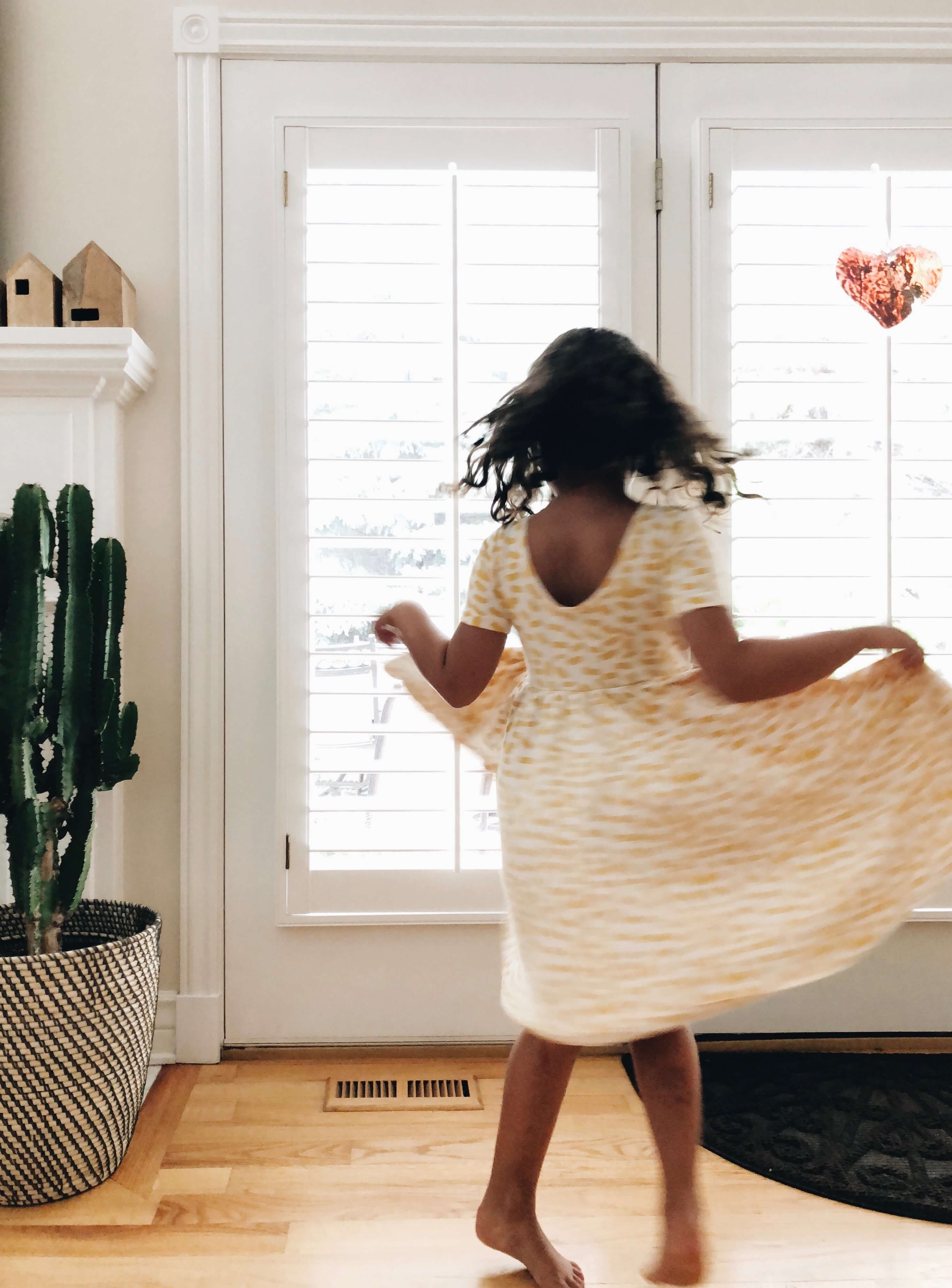 Blurry photo of little girl in polka-dot dress twirling whimsically